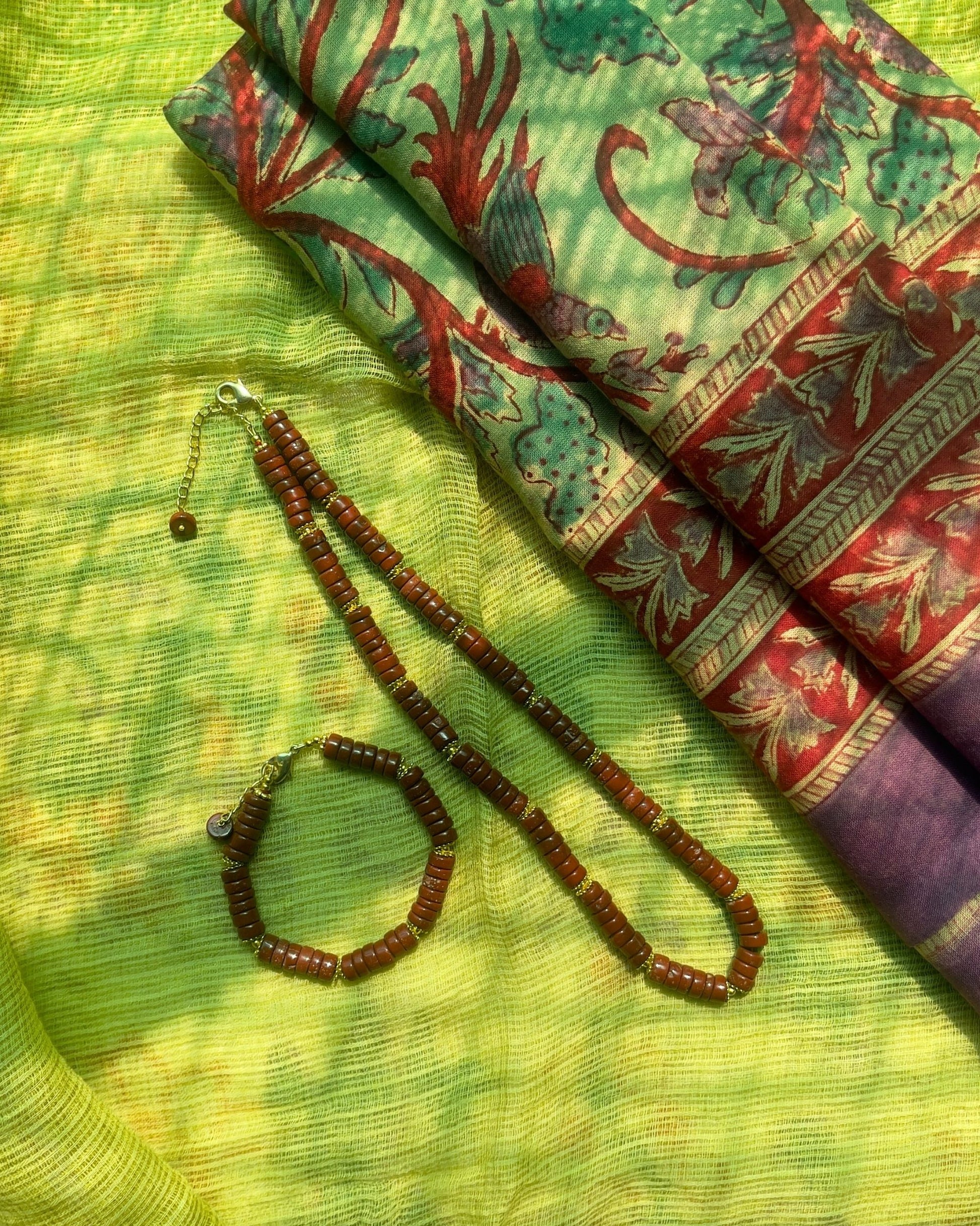 Pareo léger en voile de coton avec impression artisanale bord aubergine  violet, imprimé floral,fond vert doux style bohème, collier et bracelet en jaspe rouge