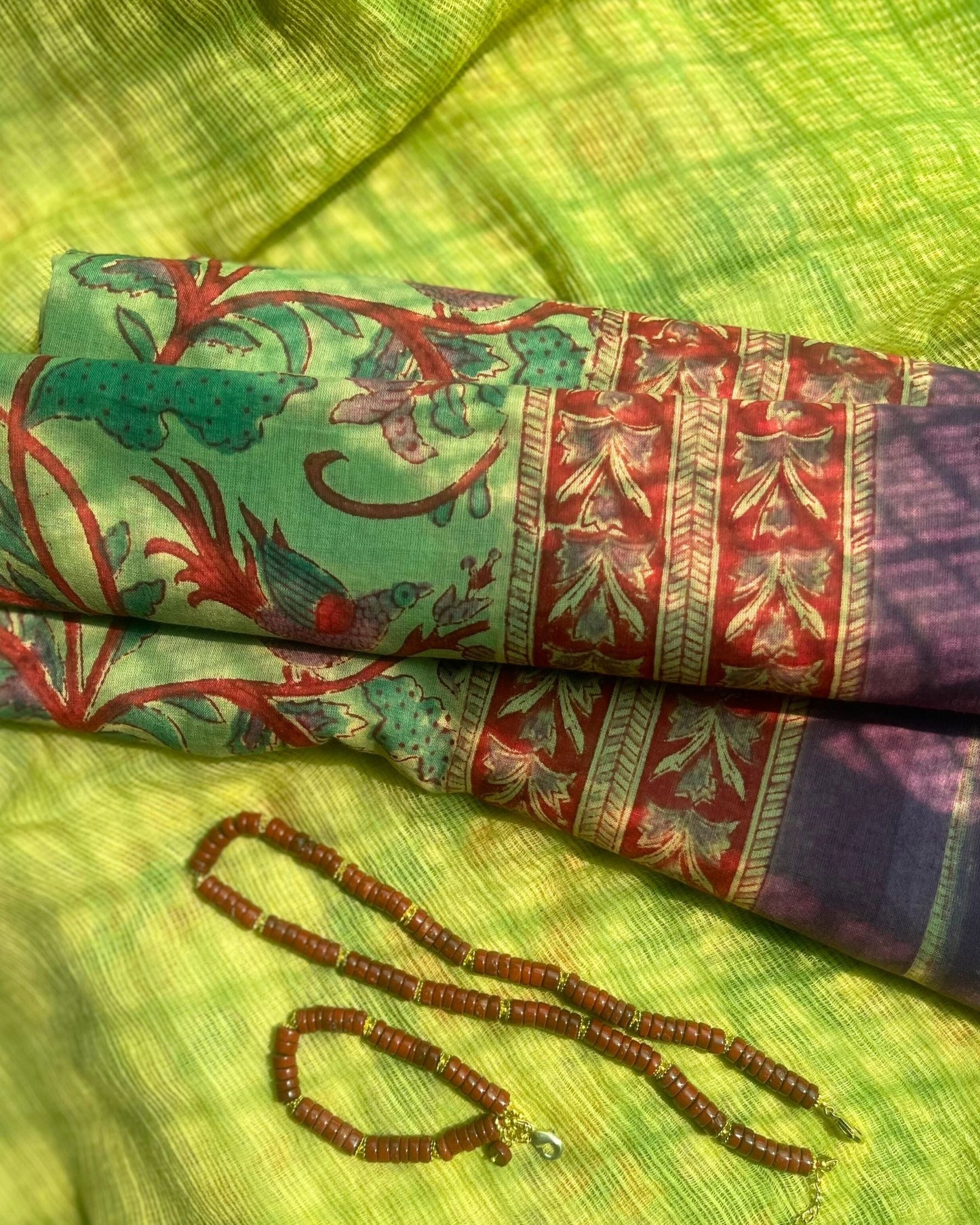 Pareo léger en voile de coton avec impression artisanale bord aubergine  violet, imprimé floral,fond vert doux style bohème, collier et bracelet en jaspe rouge