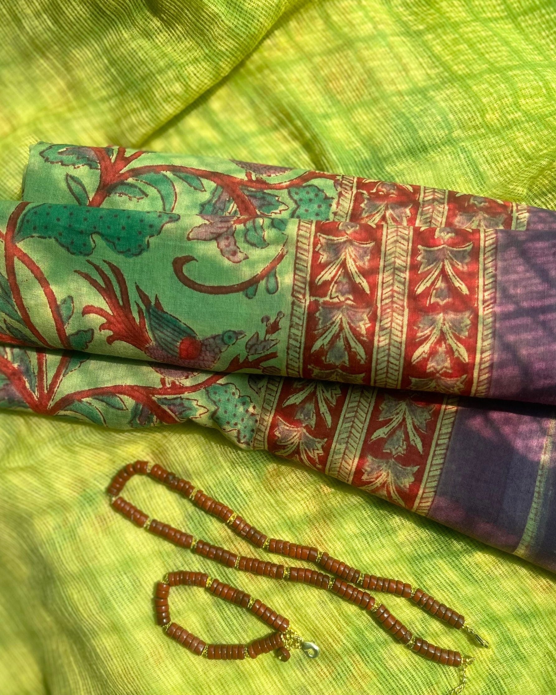 Pareo léger en voile de coton avec impression artisanale bord aubergine  violet, imprimé floral,fond vert doux style bohème, collier et bracelet en jaspe rouge