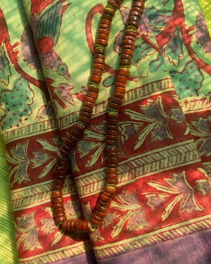 Pareo léger en voile de coton avec impression artisanale bord aubergine  violet, imprimé floral,fond vert doux style bohème, collier en jaspe rouge